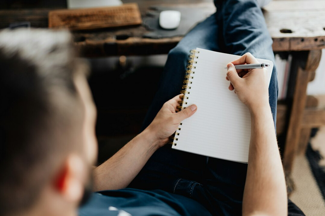 man writing notes