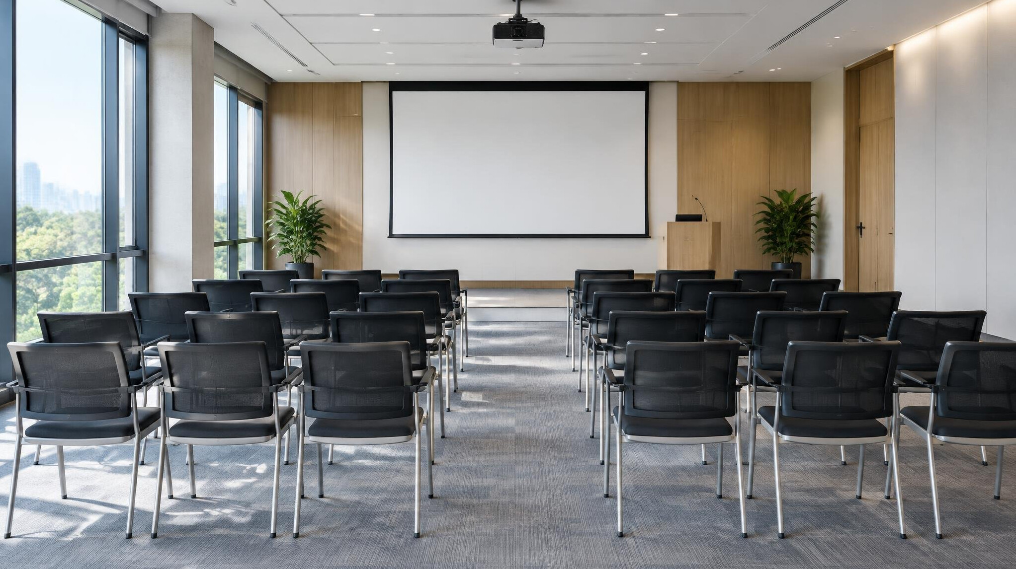Empty conference room with rows of chairs and a presentation screen